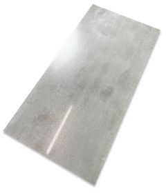 Szara płytka gresowa imitująca beton o lekko połyskującej powierzchni na białym tle